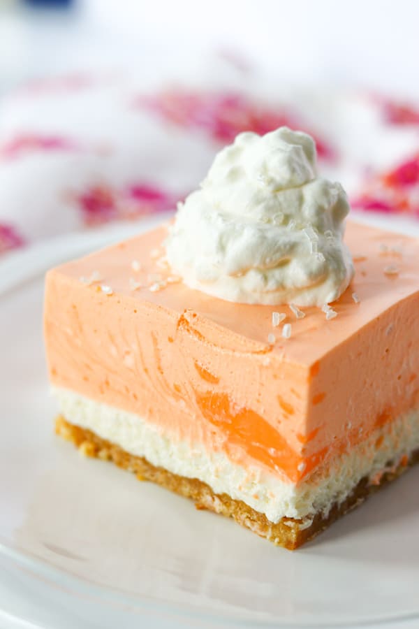 A close up of a slice of cake on a plate, with Cream and Orange