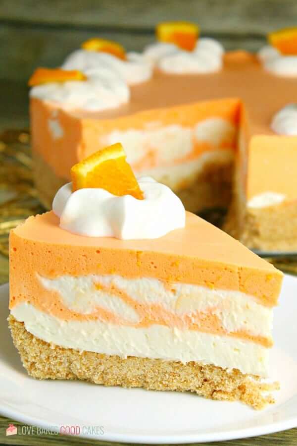 A close up of a slice of cake on a plate, with Cream and Orange
