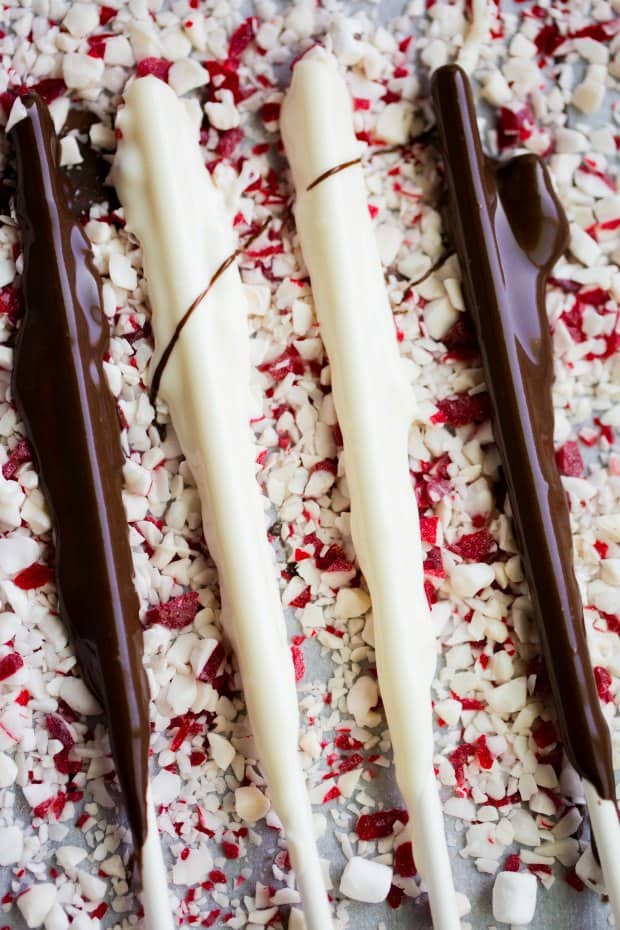 chocolate covered sticks laying on crushed peppermint