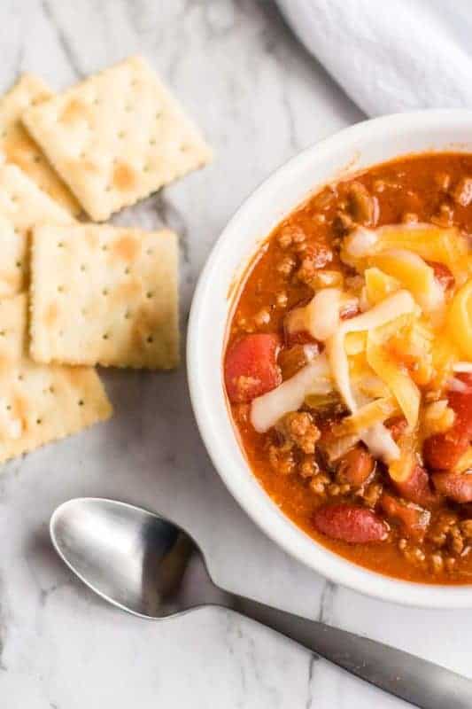 A bowl of food on a plate, with Slow cooker chili