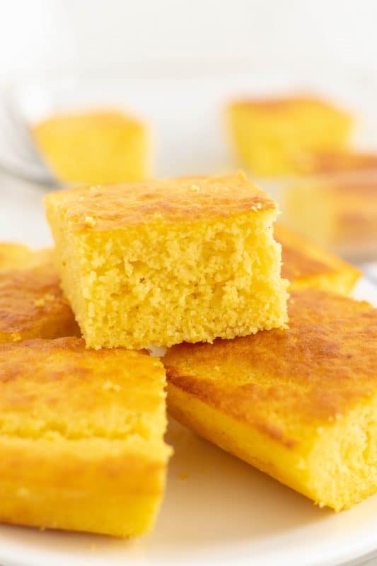 A piece of cake on a plate, with Cornbread and side