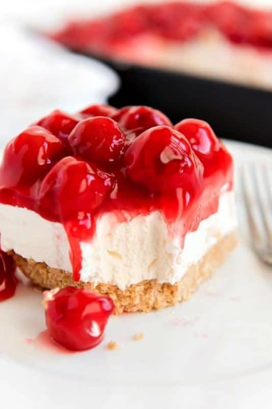 A close up of a slice of cake on a plate, with Cheesecake and Cream
