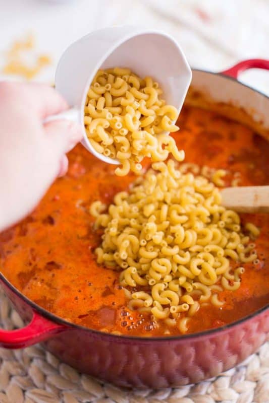 A bowl of food on a plate, with Chili mac and Cheese