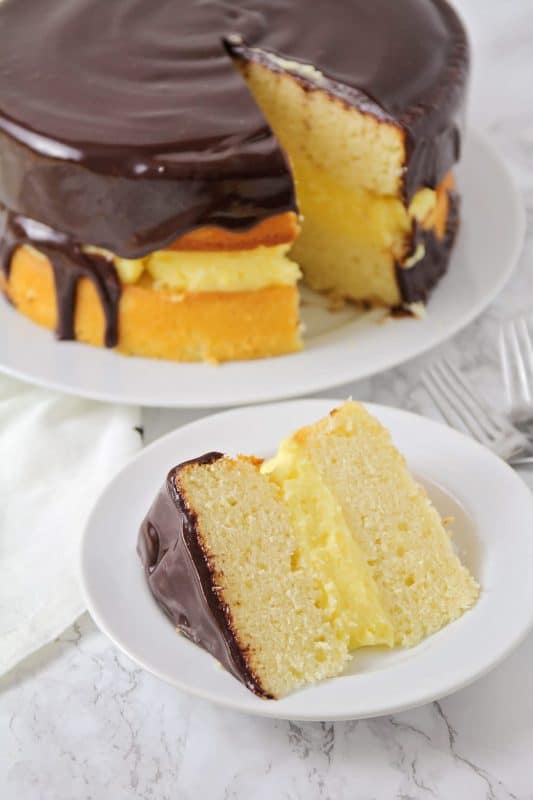 A piece of cake on a plate, with Chocolate and Boston cream pie