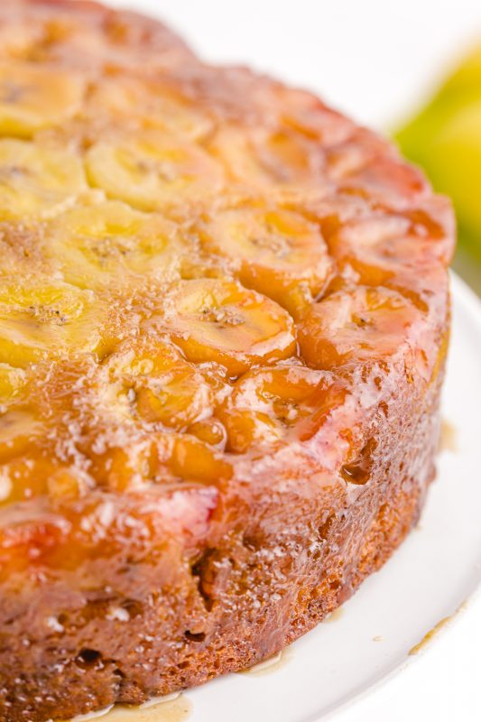 A close up of a piece of cake on a plate, with Banana upside down cake