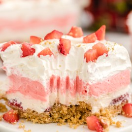 A close up of a piece of cake on a plate, with Strawberry