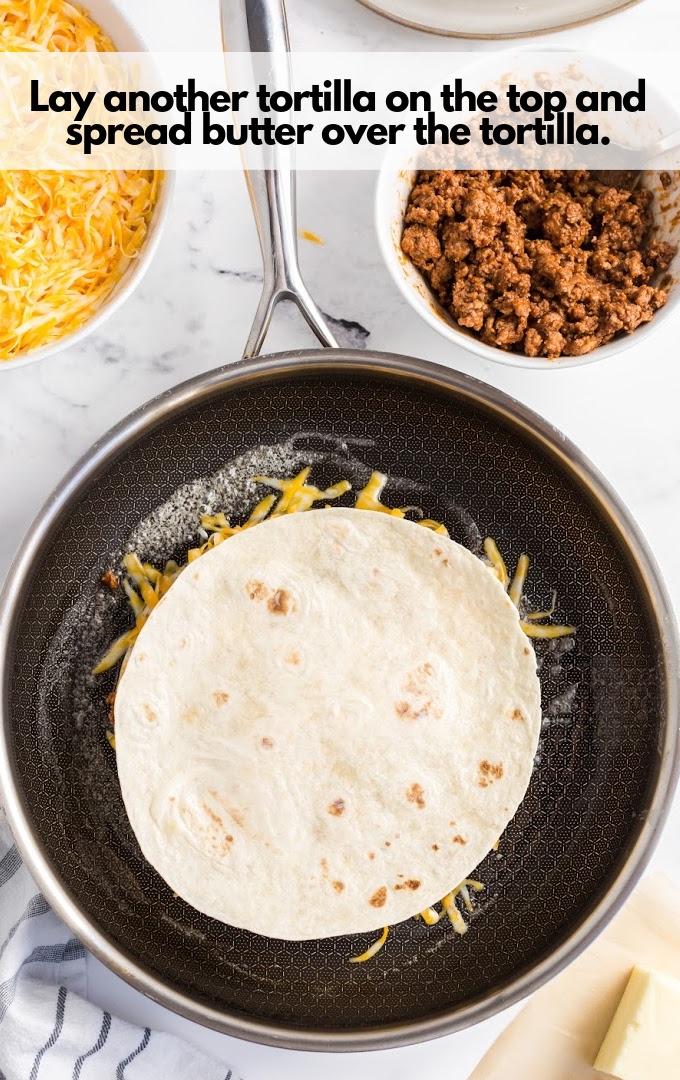 Lay another tortilla on the top and spread butter over the tortilla.