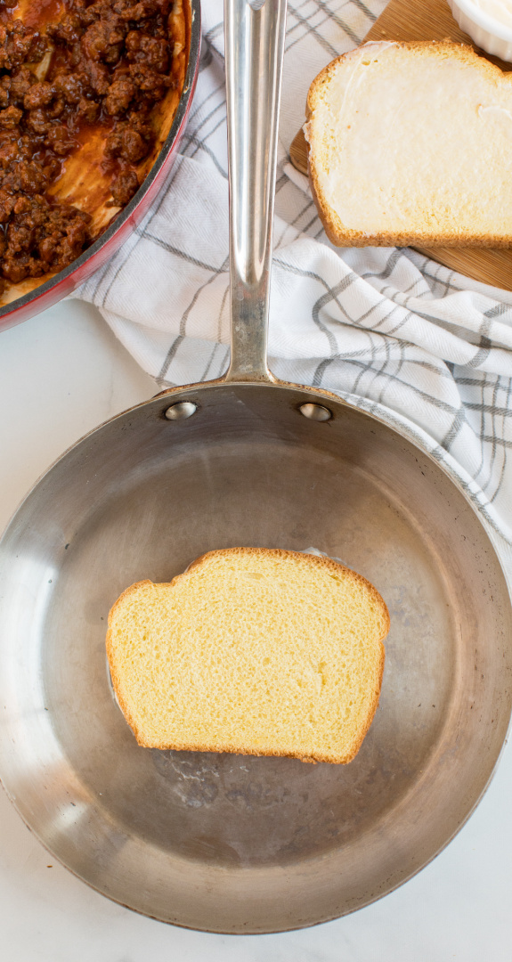 Lightly butter bread and put one slice in the pan