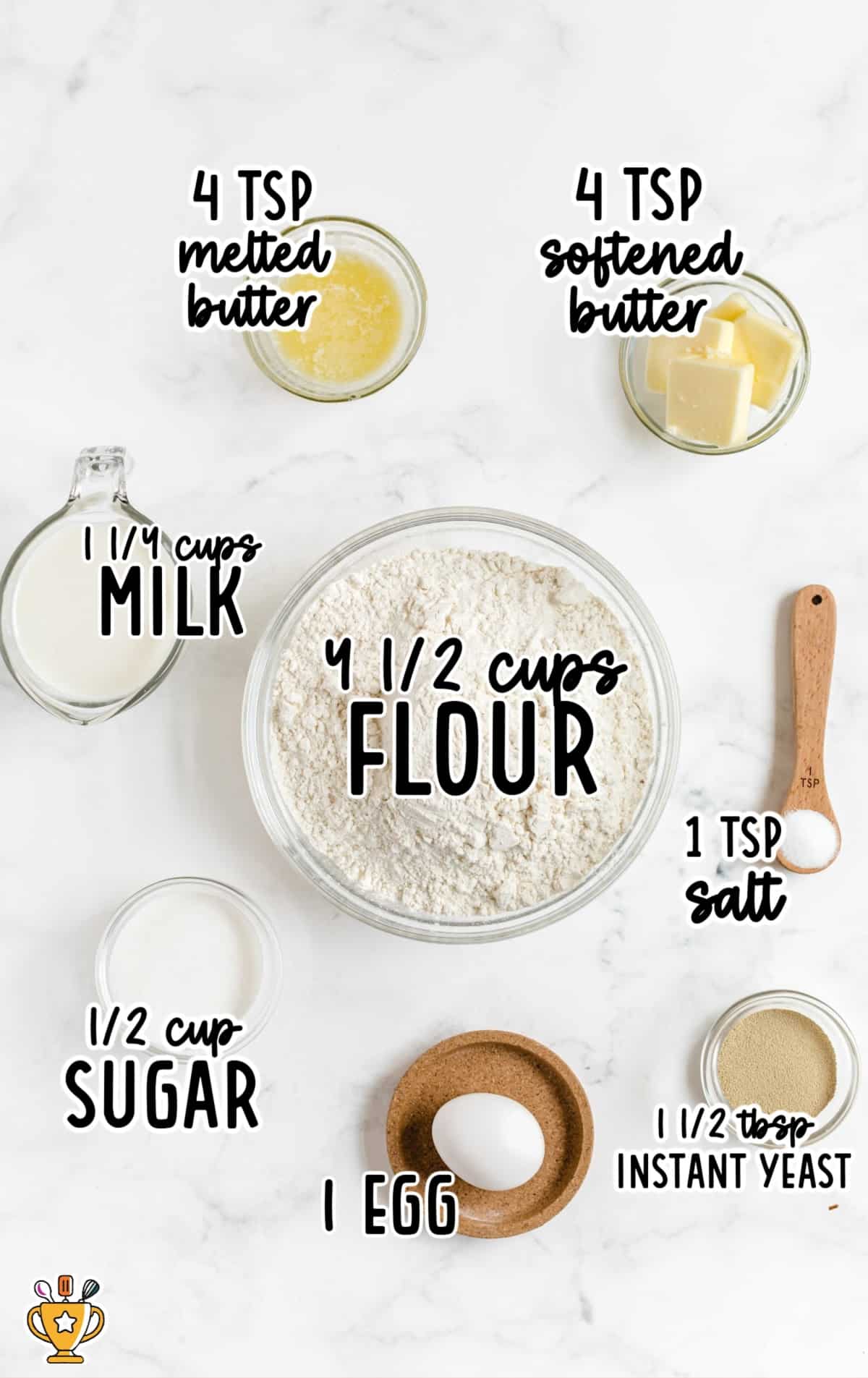 Overhead view of dinner roll ingredients on a white surface including flour, milk, sugar, yeast, egg, salt, and butter, neatly arranged for an easy homemade yeast dinner roll recipe.