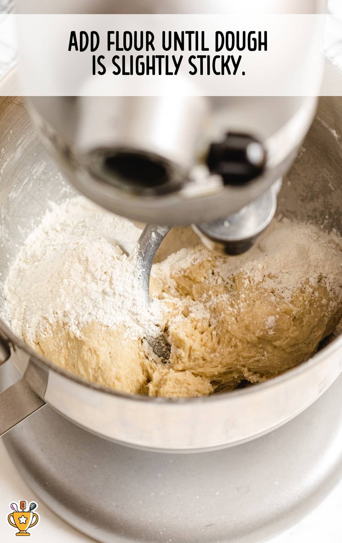 Stand mixer mixing homemade dinner roll dough as flour is gradually added, showing slightly sticky yeast dough forming for soft, fluffy dinner rolls made from scratch.