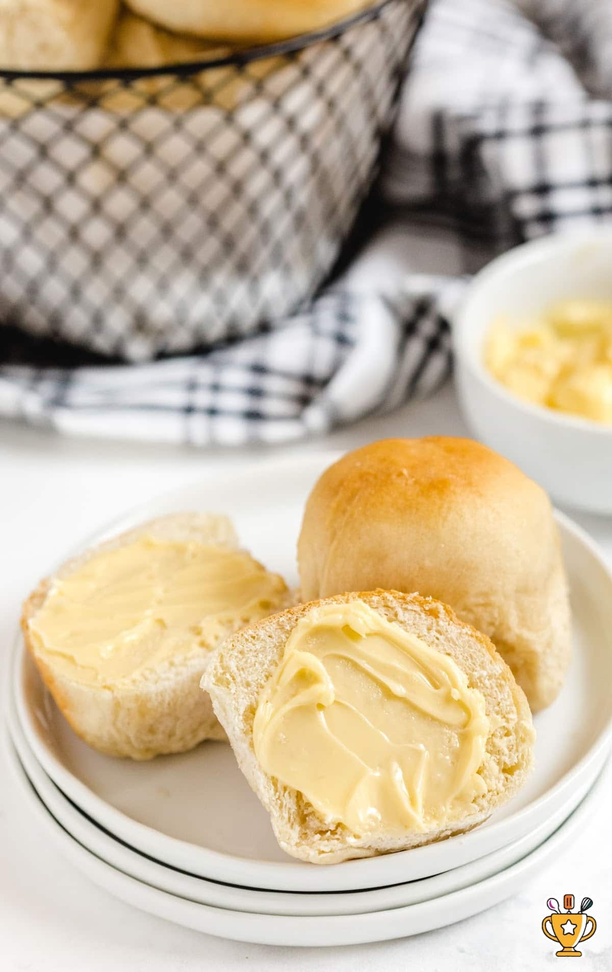 Soft, fluffy dinner rolls baked close together in a glass baking dish, lightly browned on top and brushed with butter, showcasing classic homestyle yeast rolls made from scratch.