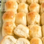 Tall Pinterest image of golden homemade dinner rolls baked in a glass dish with text overlay reading &ldquo;The Best Dinner Rolls,&rdquo; highlighting soft, fluffy, bakery-quality rolls made easily at home.