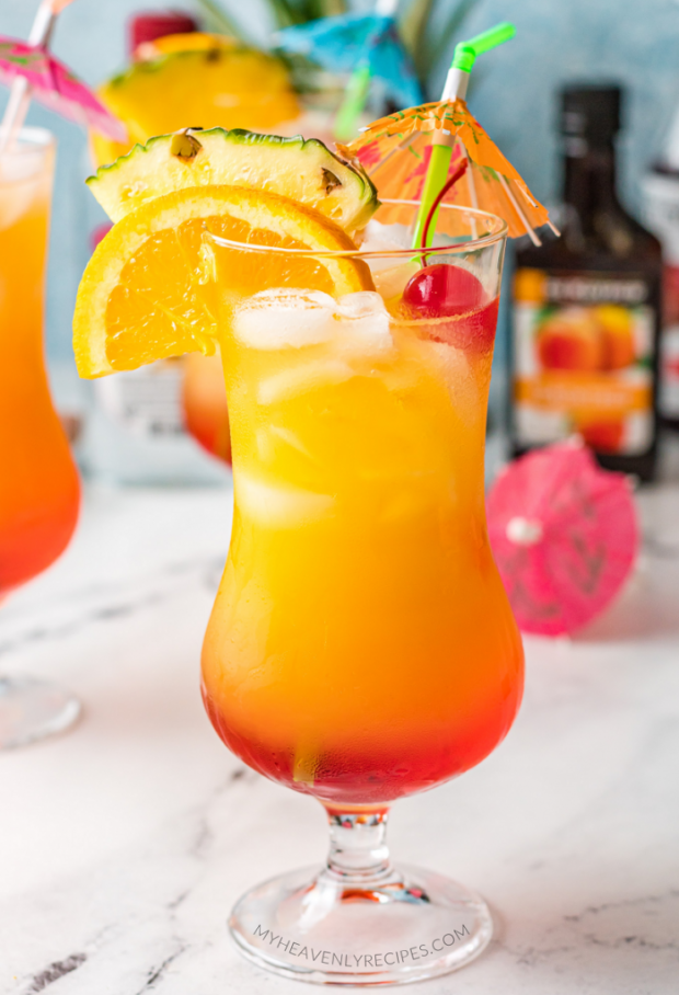 A close up of a glass of orange juice, with Vodka and Malibu