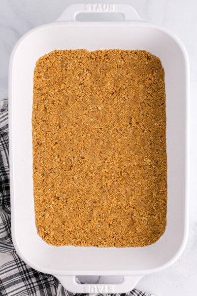 Graham crackers and pecans being pulsed in a food processor