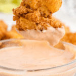 chicken finger dipping sauce in a bowl with a chicken tender being dipped into it
