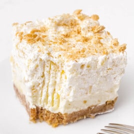 A square slice of Pineapple Delight with a bite out of it.