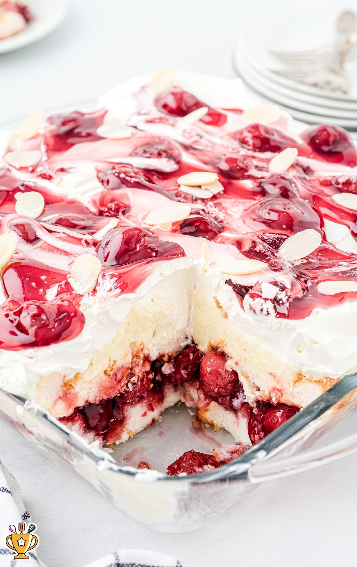 A heaven on earth cake in a glass baking dish with a piece out of it.