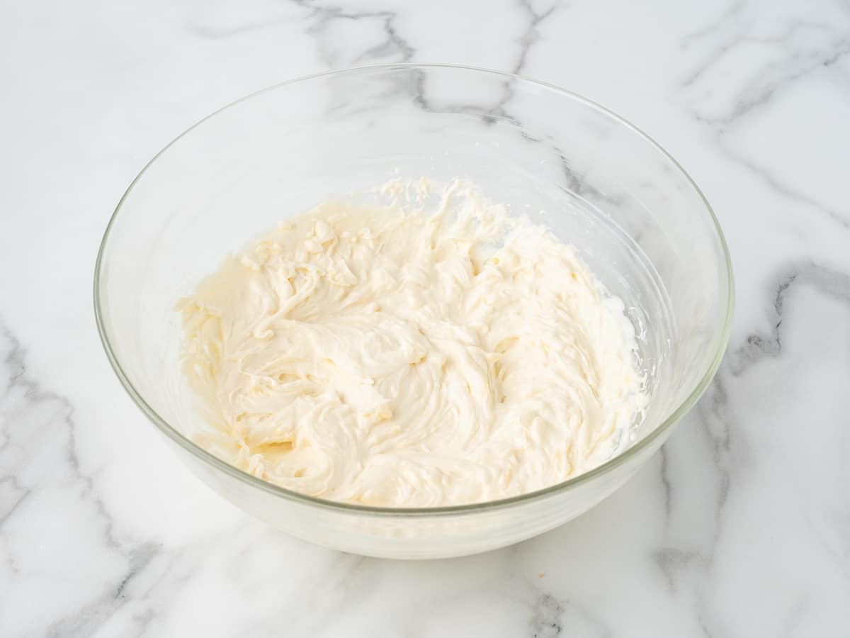 Smooth cream cheese filling mixed in a glass bowl for pineapple delight.
