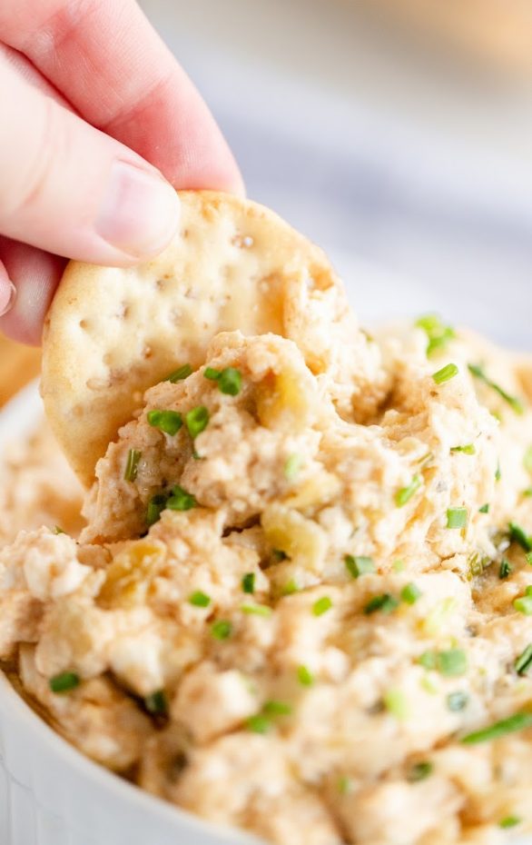 A close up of a piece of food, with Crab dip and Sauce