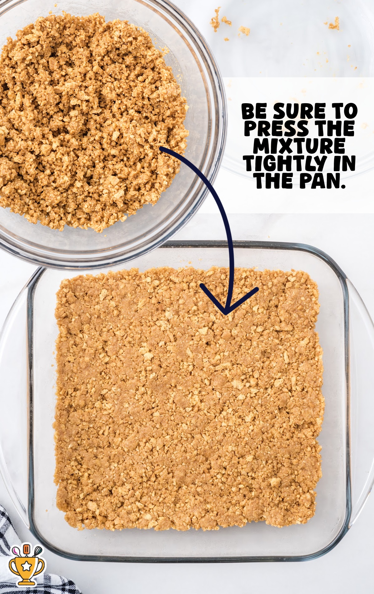 Process shot showing crushed peanut butter sandwich cookie crust mixture in a glass bowl and pressed into a square baking dish. Text overlay says, &ldquo;Be sure to press the mixture tightly in the pan.&rdquo; Step-by-step image for peanut butter dream bars crust preparation.