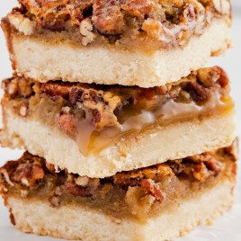 A sandwich sitting on top of a piece of cake on a plate, with Pecan