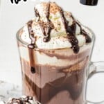Tall glass mugs filled with spiked hot chocolate topped with whipped cream and chocolate drizzle, labeled “warm and cozy spiked hot chocolate - the perfect grown-up treat for winter.