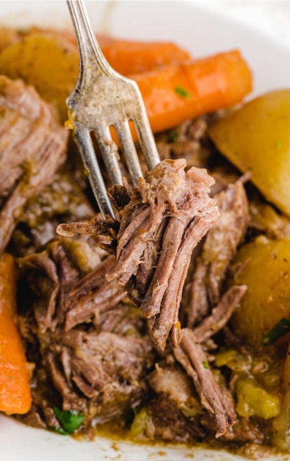 A plate of food with a fork, with Pot roast and Beef