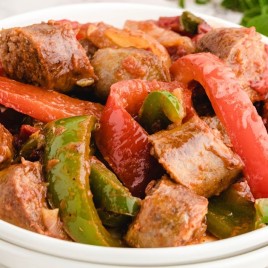 A plate of food with stew, with Sausage