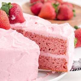A piece of cake on a plate, with Strawberry