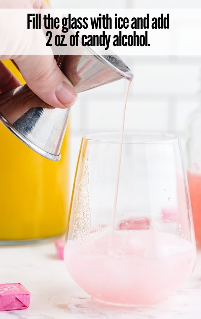 adding ice and candy alcohol in a glass