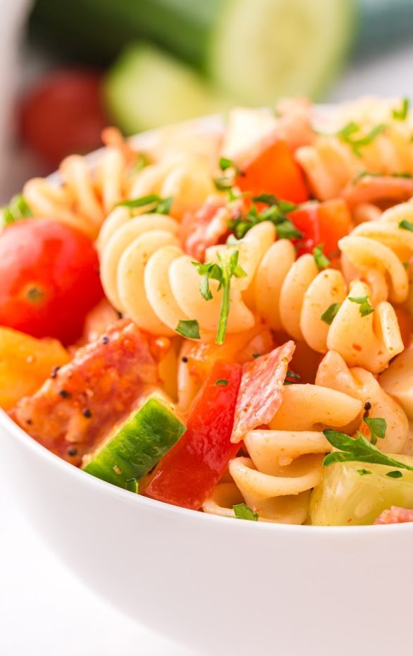 A bowl of food on a plate, with Pasta and Salad