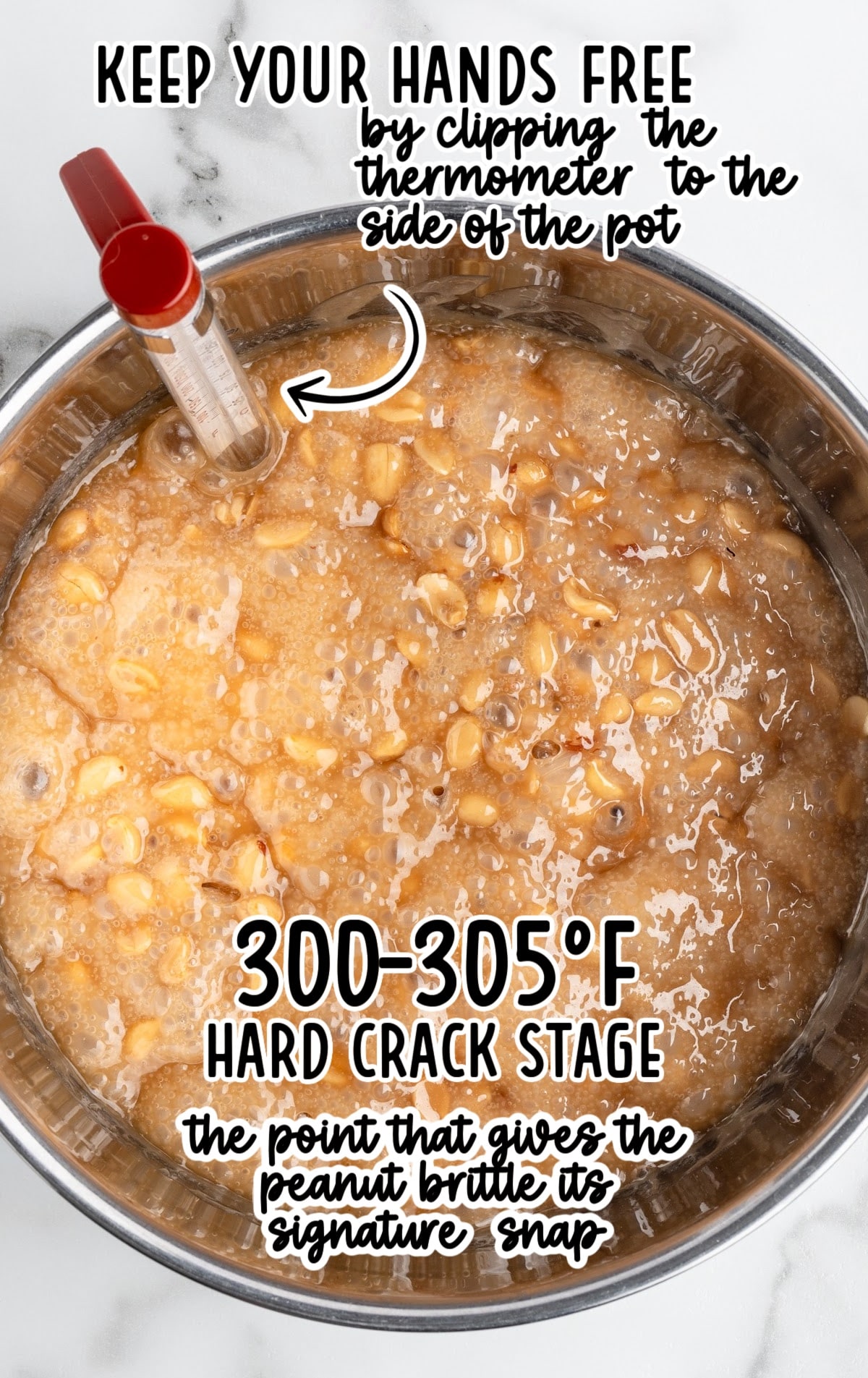 Boiling peanut brittle mixture in a stainless-steel pot with peanuts suspended in bubbling caramel and a clipped candy thermometer reading hard-crack stage at 300&ndash;305&deg;F.