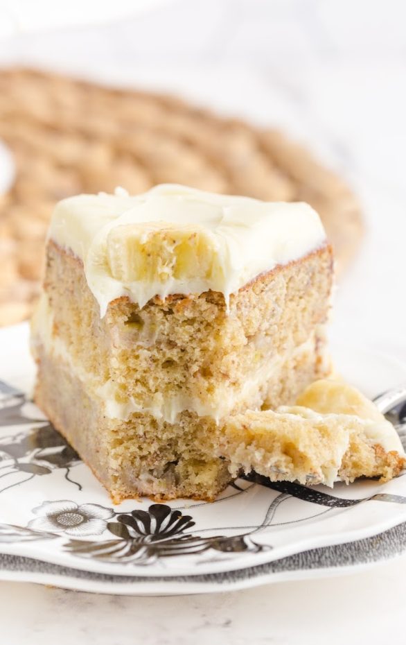 A piece of cake on a plate, with Banana and Bread