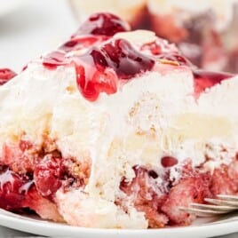 A slice of Strawberry Heaven on Earth Cake on a white dessert plate.