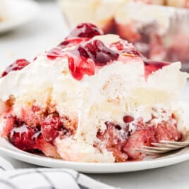 A slice of Strawberry Heaven on Earth Cake on a white dessert plate.