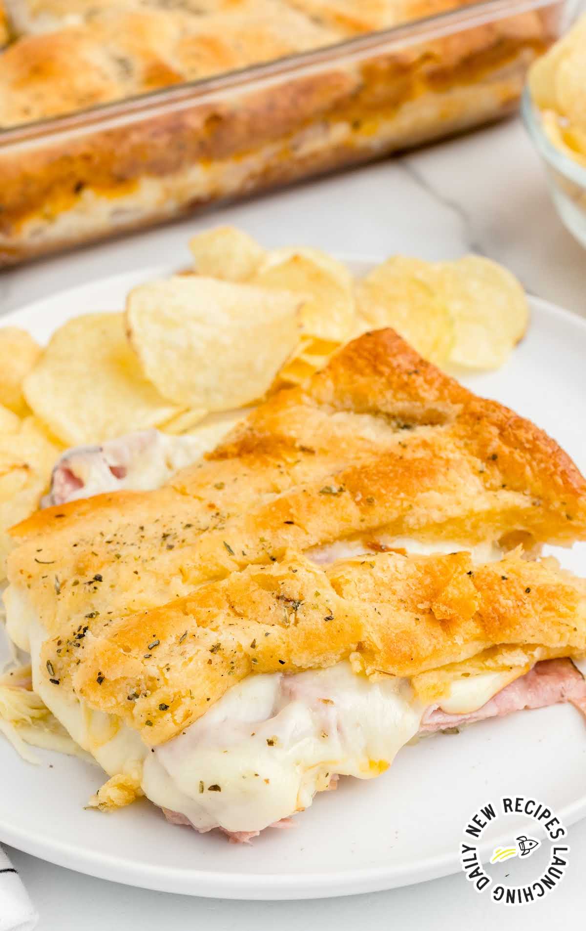 A piece of food on a plate, with Cheese and Ham