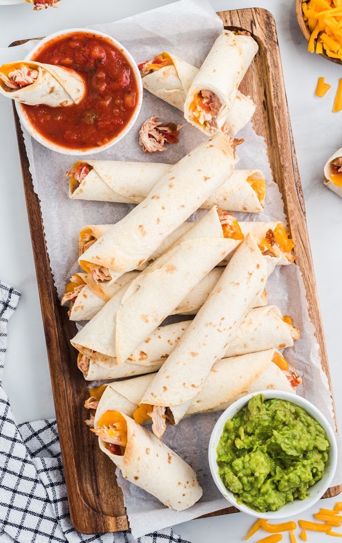 A plate of food on a table, with Taquitos