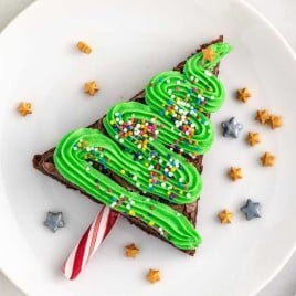 A plate of food with a slice of cake on a table, with Christmas
