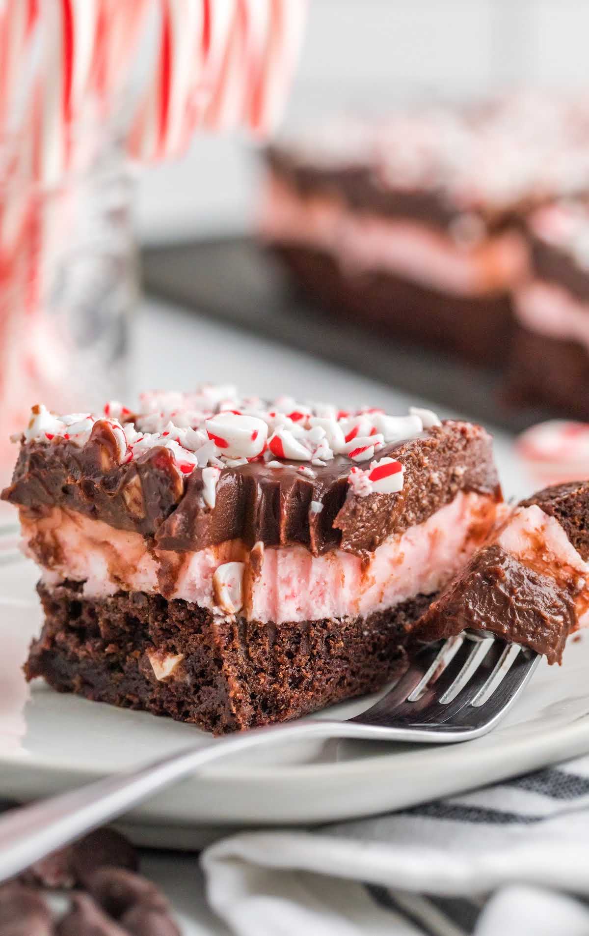 A piece of chocolate cake on a plate, with Peppermint brownies and Cream