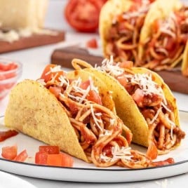 A plate of food on a table, with Spaghetti and Taco