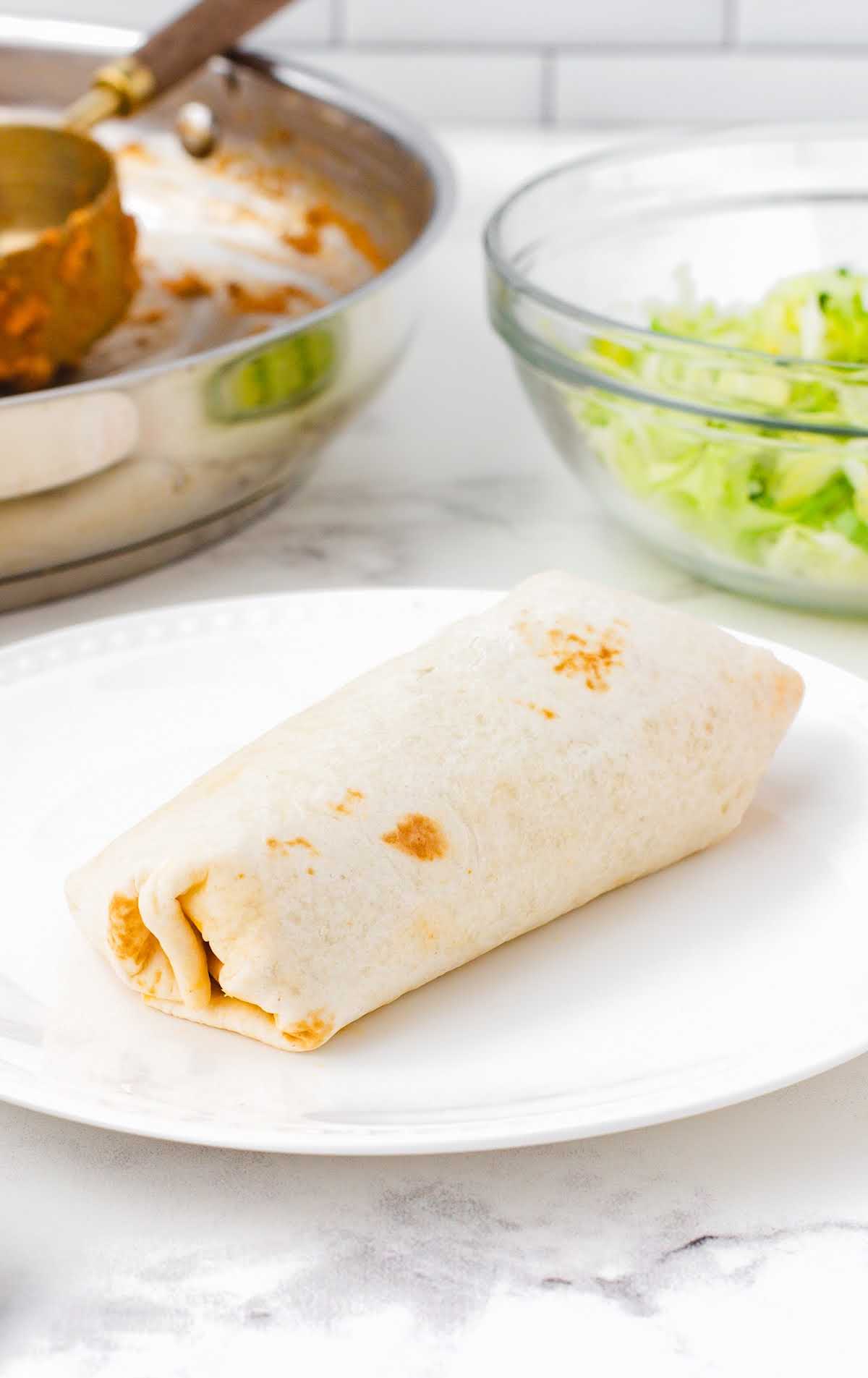 A plate of food on a table, with Burrito and Tortilla