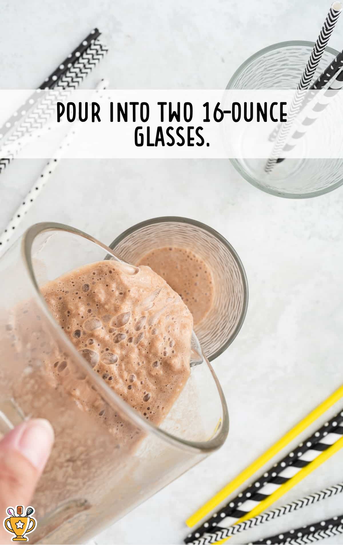 The banana coffee breakfast smoothie is poured out of the blender and into a glass.