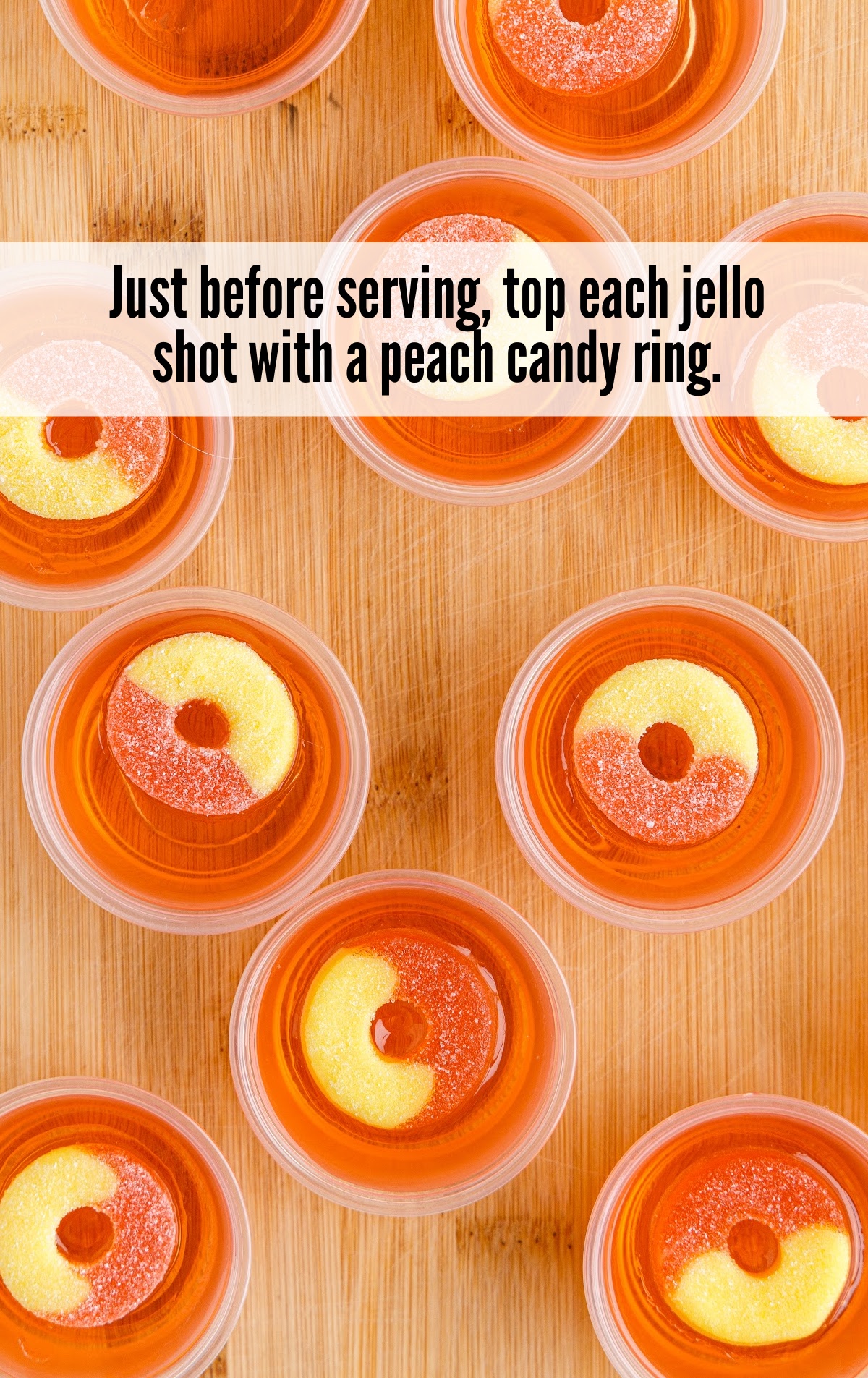 A wooden table topped with plates of food on a plate, with Peach and Jello shot