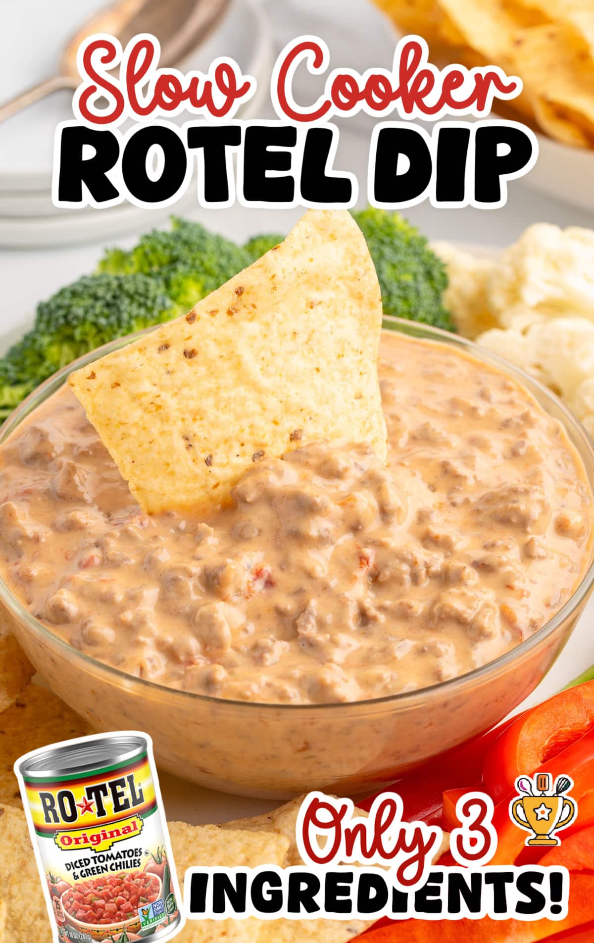 Close-up of cheesy Crockpot Rotel dip with ground beef and tomatoes, topped with a tortilla chip for dipping, with broccoli and cauliflower in the background.