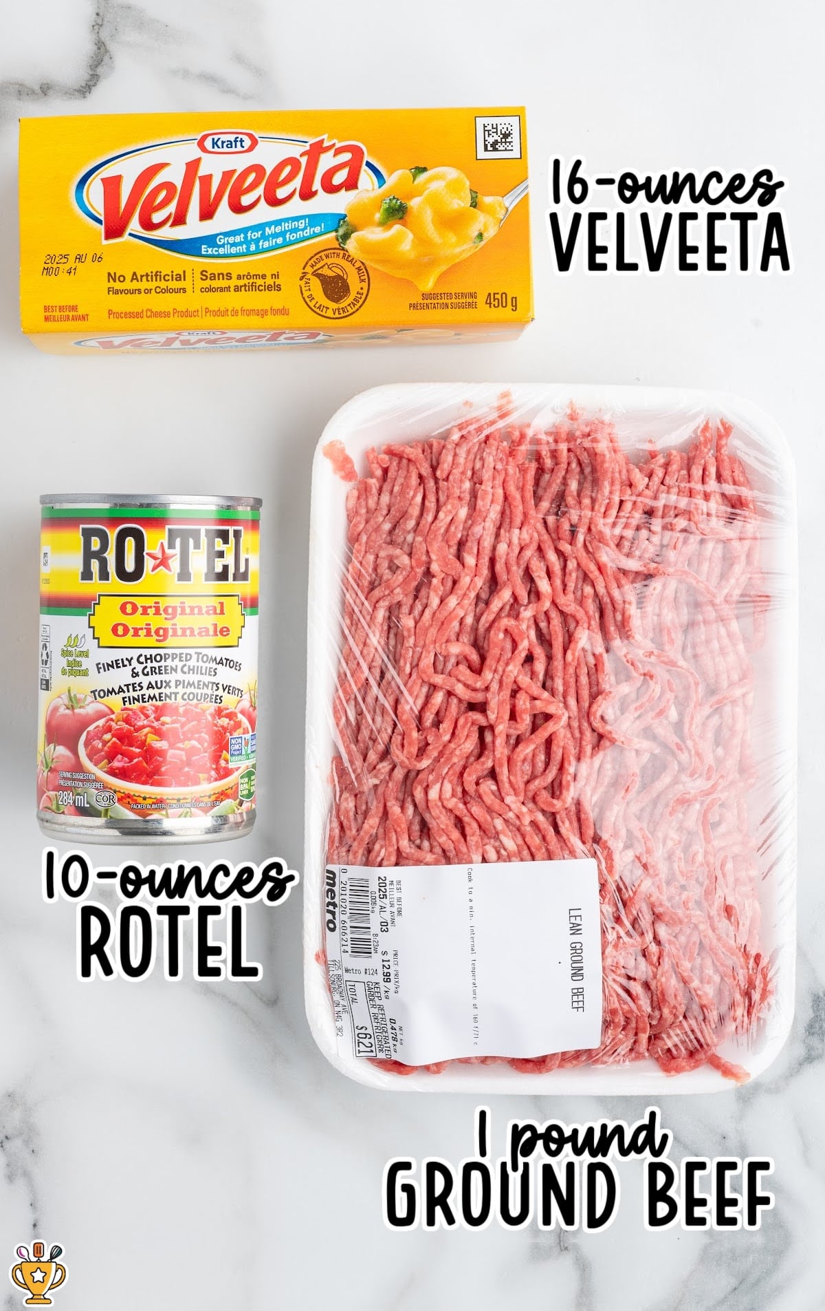 Overhead image of the three ingredients needed for slow cooker Rotel dip, including a block of Velveeta cheese, a can of Rotel tomatoes with green chiles, and a package of raw ground beef on a marble surface.