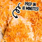 Close-up of cheesy Doritos chicken casserole being scooped from a glass baking dish, showing melted cheese, crushed nacho chips, and creamy chicken filling.