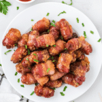 bacon wrapped smokies on a white plate ready to eat