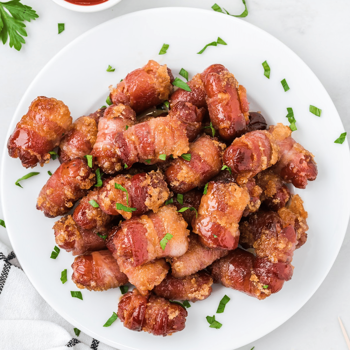 oven baked little smokies wrapped in bacon on a white plate