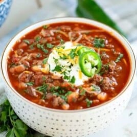 chili with beans in a bowl with sour cream and jalapeno
