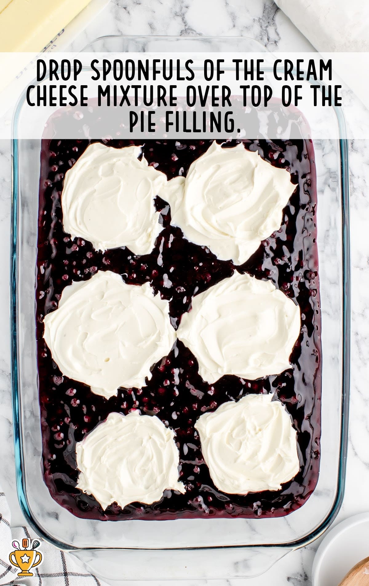 blueberry pie filling with a sweet cream cheese mixture in a 9x13 baking dish